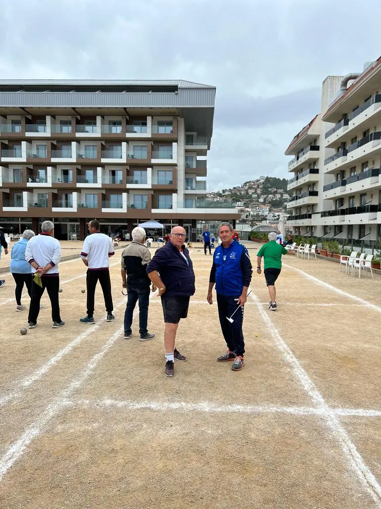 Giocatori di bocce sui campi con l’hotel sullo sfondo