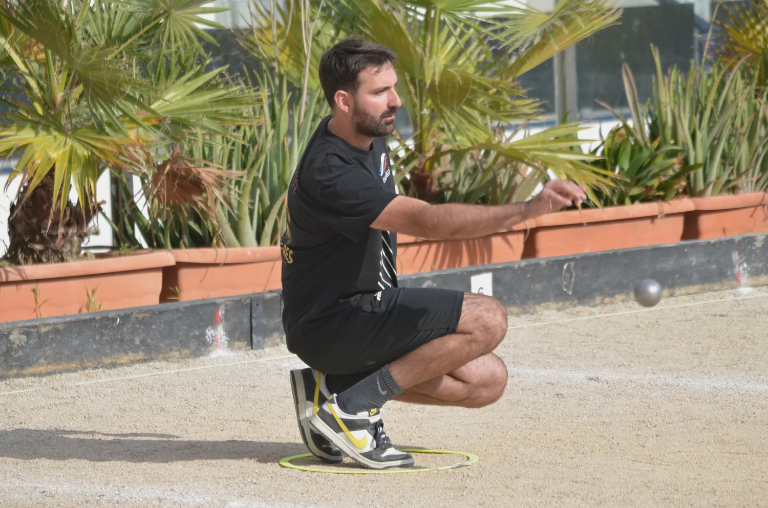 Giocatore che lancia la boccia al torneo di petanque