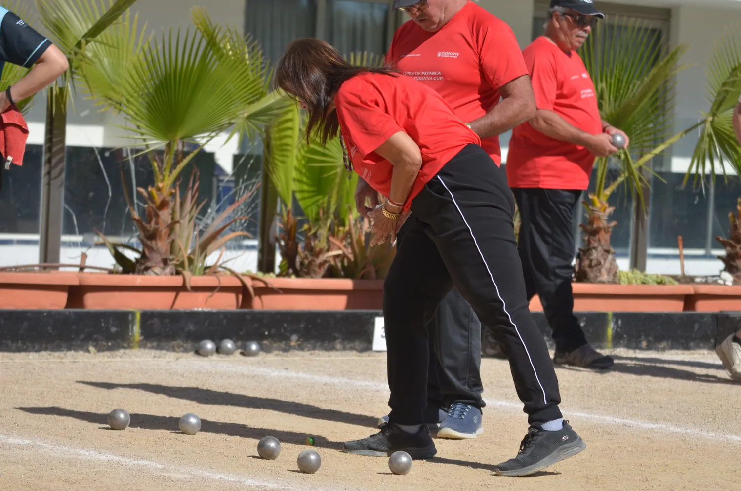 Giocatori di una squadra seguono il gioco vicino alle bocce in campo