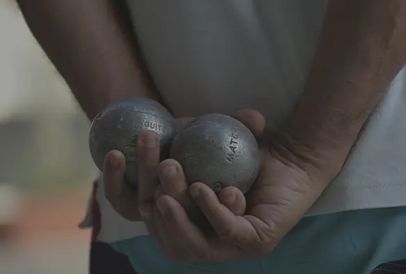 Jugador de petanca sujetando las bolas